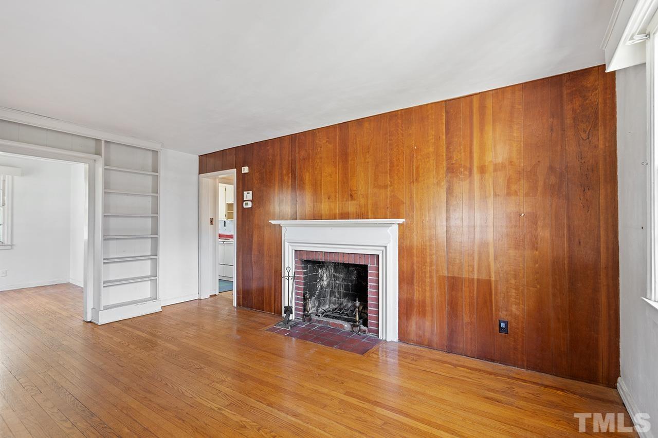 1208 Clifton Street Raleigh, NC 27604 - Photo 13 of 33 an empty room with wooden floor fireplace and windows
