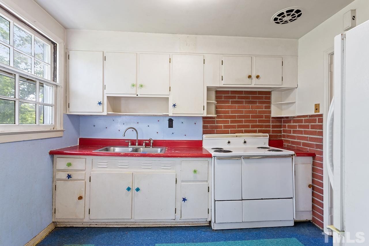 1208 Clifton Street Raleigh, NC 27604 - Photo 16 of 33 a kitchen with cabinets and white appliances