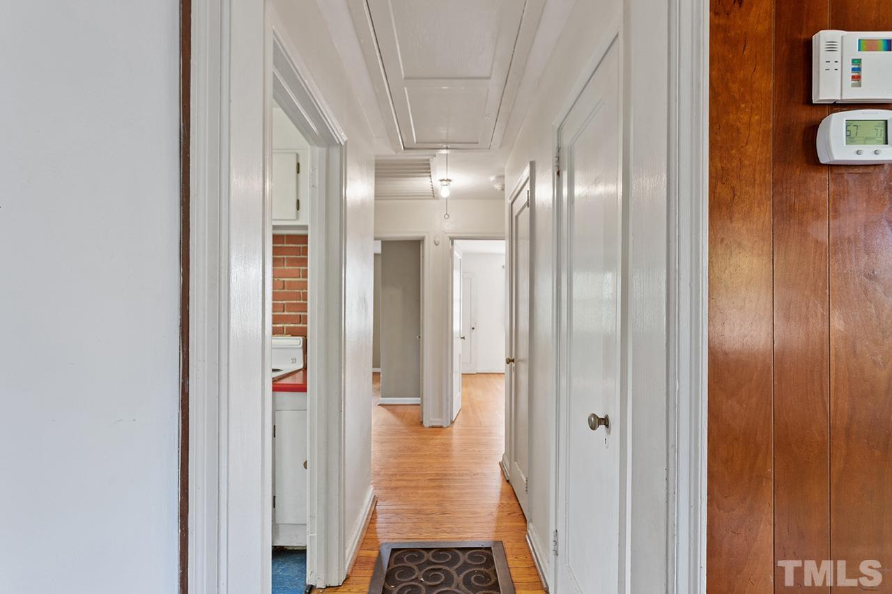 1208 Clifton Street Raleigh, NC 27604 - Photo 20 of 33 a view of a hallway with wooden floor and a bathroom
