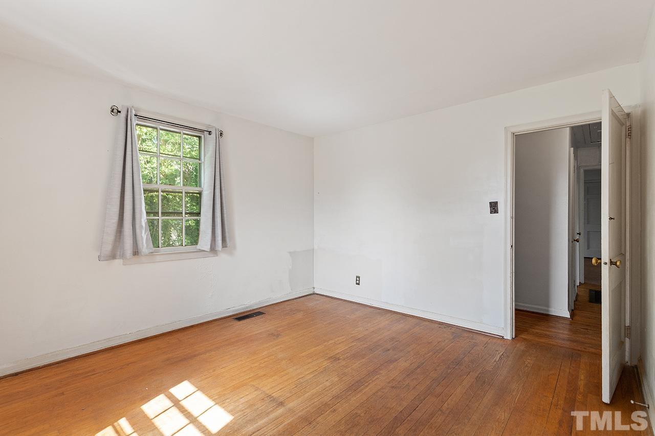 1208 Clifton Street Raleigh, NC 27604 - Photo 27 of 33 a view of an empty room with wooden floor and a window