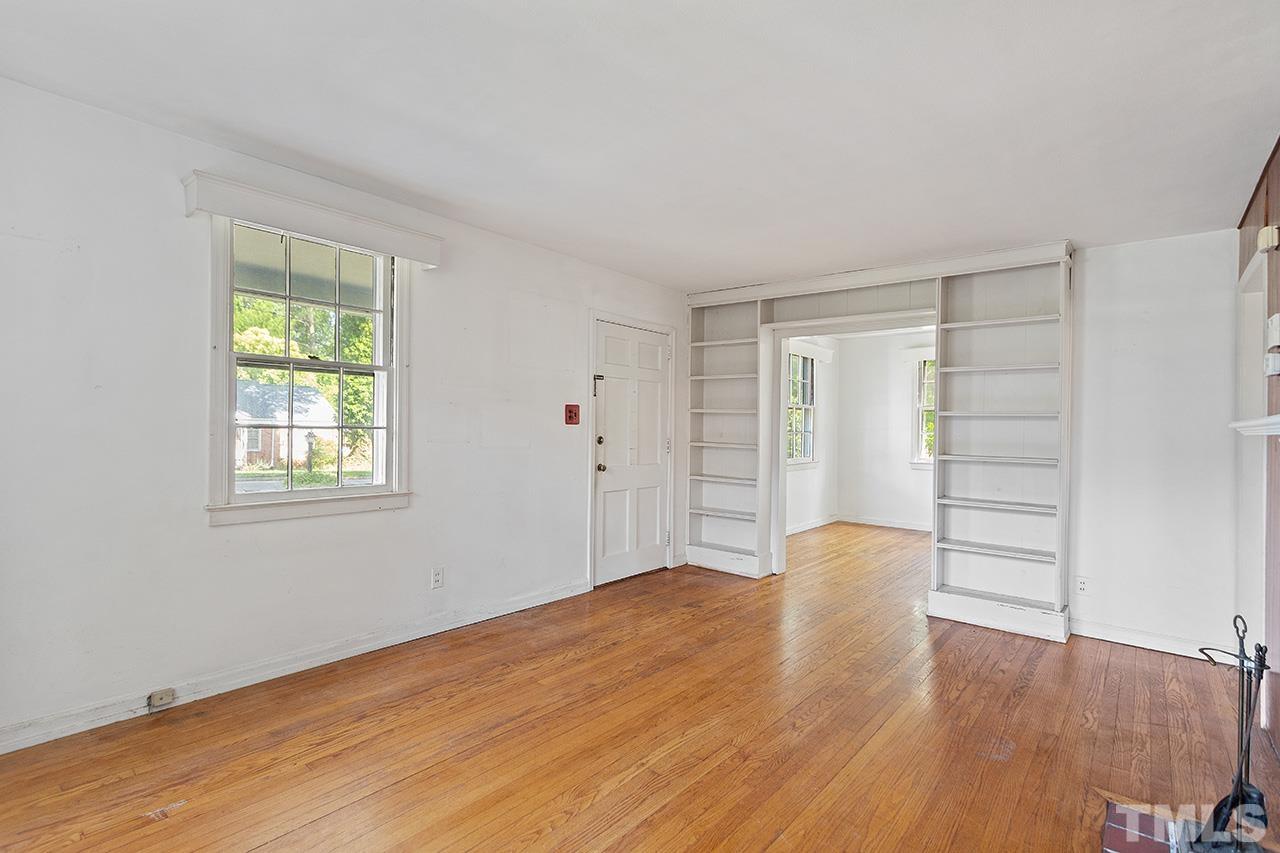 1208 Clifton Street Raleigh, NC 27604 - Photo 4 of 33 a view of an empty room with wooden floor and a window