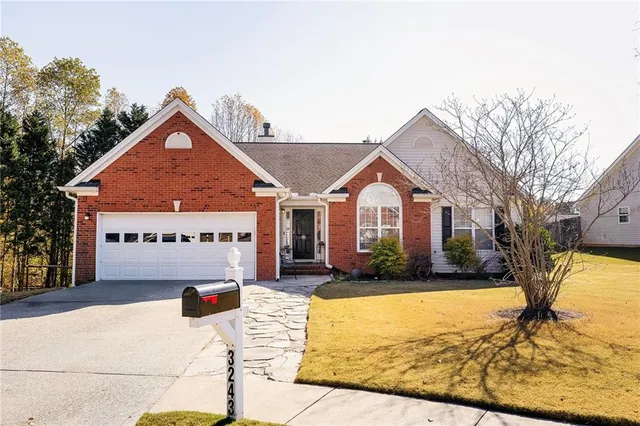 a front view of house with yard outdoor seating and covered with trees