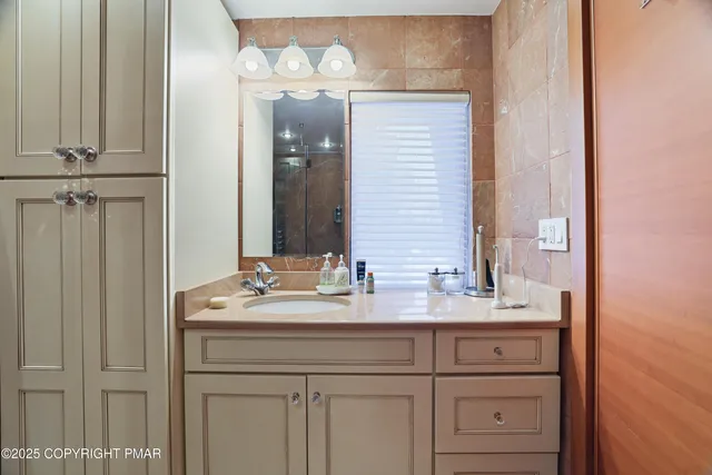 a bathroom with a granite countertop sink and a mirror