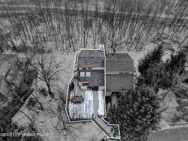 a front view of a house with a yard covered in snow