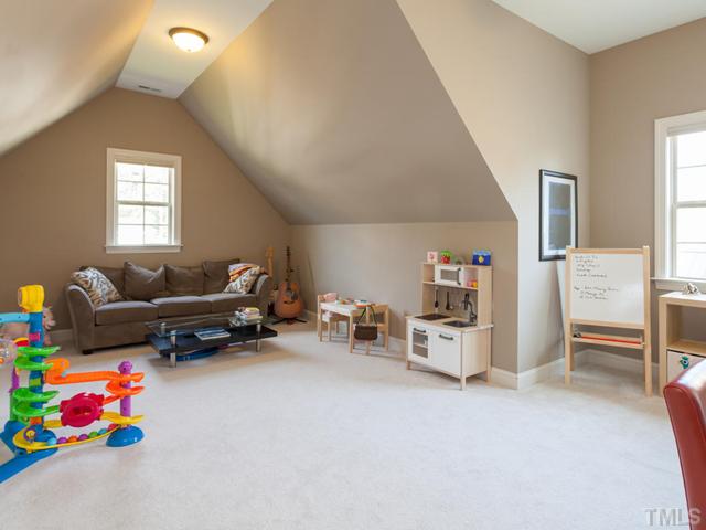 4736 Adler Pass Raleigh, NC 27612 - Photo 17 of 25 The second floor bonus room provides a versatile layout for fun and games. Not visible in this photograph is a long built-in wood bench that runs along the wall to the left. This room has a closet so it could be also be used as a 6th bedroom.