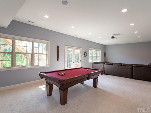 4736 Adler Pass Raleigh, NC 27612 - Photo 19 of 25 The 38.3 ft x 18 ft rec room is located in the basement and enjoys natural light from the wall of windows. Additional features include remove-controlled blinds, recessed lighting, bar with beverage frig, distributed audio and access to walk-in storage.