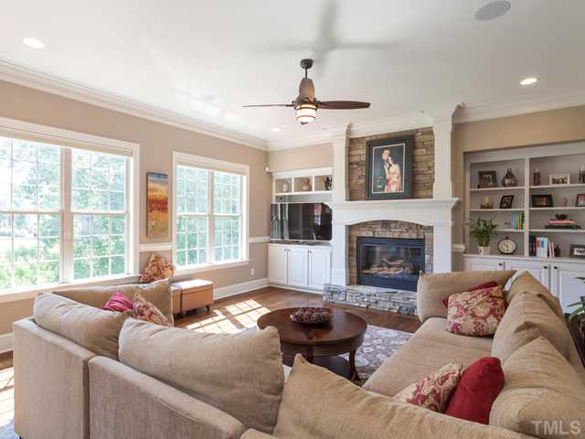 4736 Adler Pass Raleigh, NC 27612 - Photo 5 of 25 Custom bookcases frame the gas fireplace with stone surround. Additional features of the family room include distributed audio, ceiling fan, and a view of the private protected tree area in the backyard.