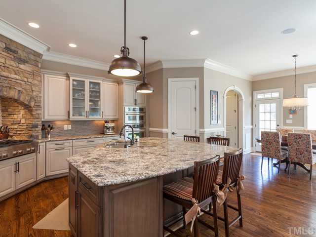 4736 Adler Pass Raleigh, NC 27612 - Photo 7 of 25 The kitchen provides a large walk in pantry, crown molding, upscale urban lighting and it is open to the breakfast room. The arched doorway leads to a built-in storage cubby and the 1st floor guest suite.