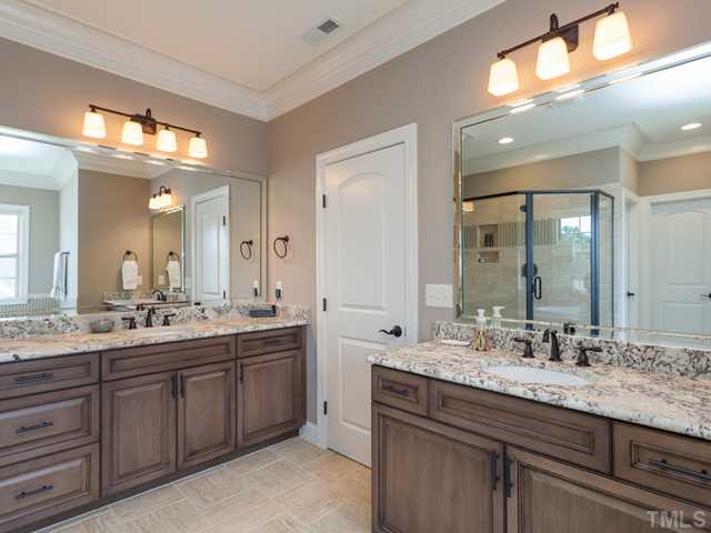 4736 Adler Pass Raleigh, NC 27612 - Photo 10 of 25 The master bath features distinctive ceramic tile floors, heavy crown molding, a water/toilet closet, and 2 custom bath vanities with granite counter tops and oil rubbed bronze fixtures.