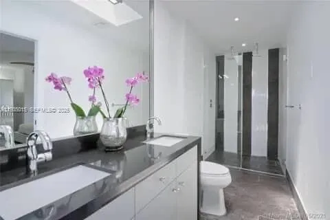 a bathroom with a granite countertop sink a toilet and a shower