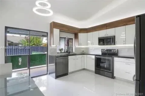 a kitchen with kitchen island a sink stainless steel appliances and cabinets