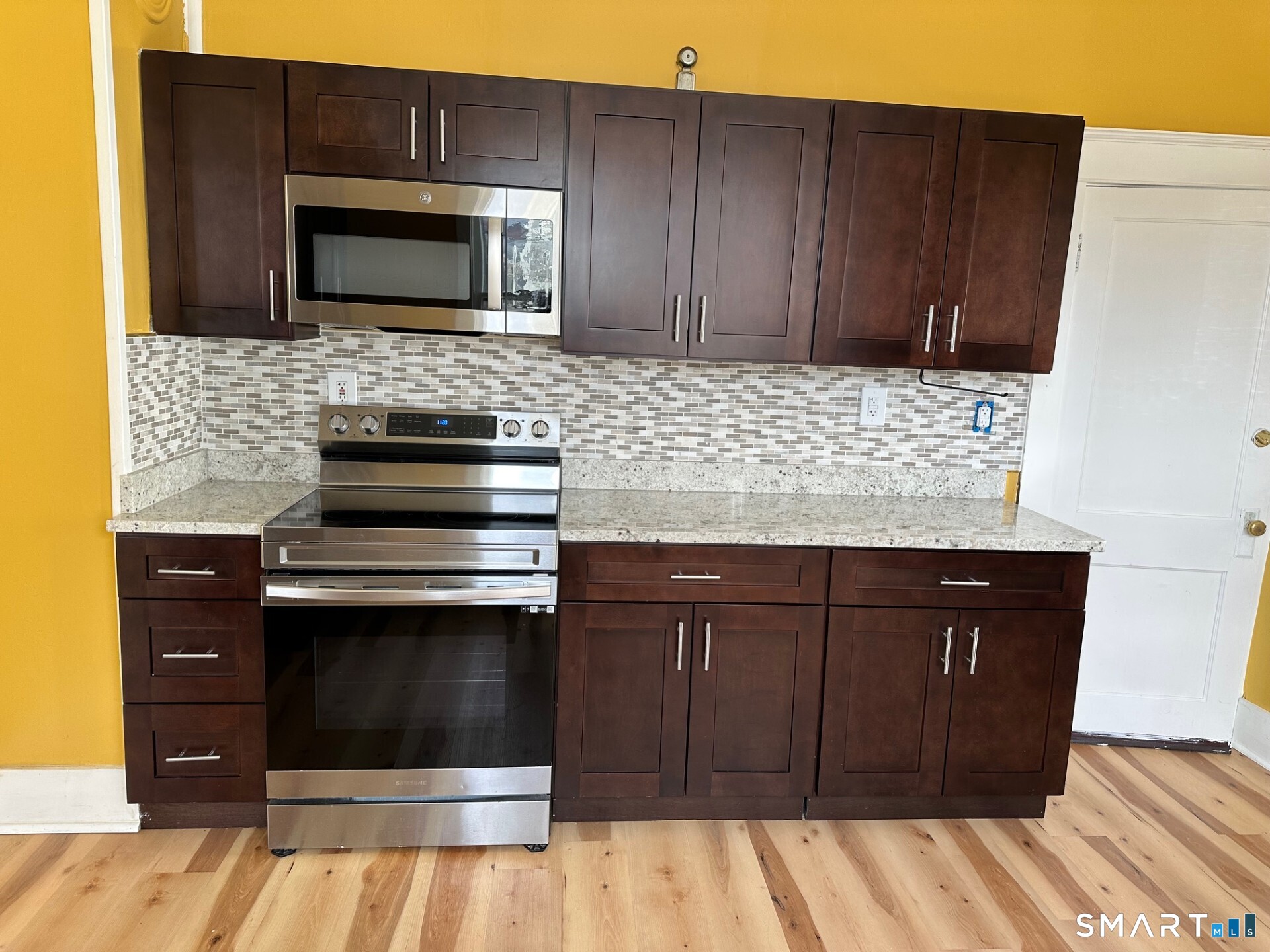 a kitchen with granite countertop wooden cabinets and stainless steel appliances