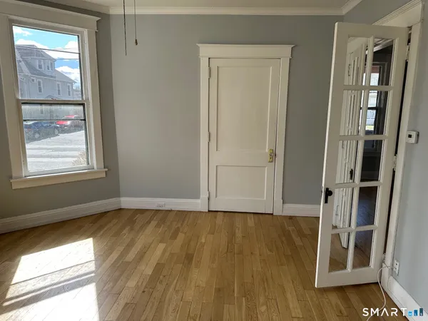 an empty room with wooden floor and windows