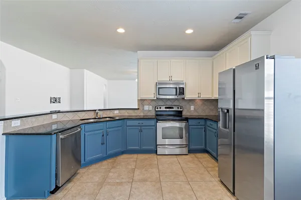 a kitchen with stainless steel appliances granite countertop a refrigerator and a sink