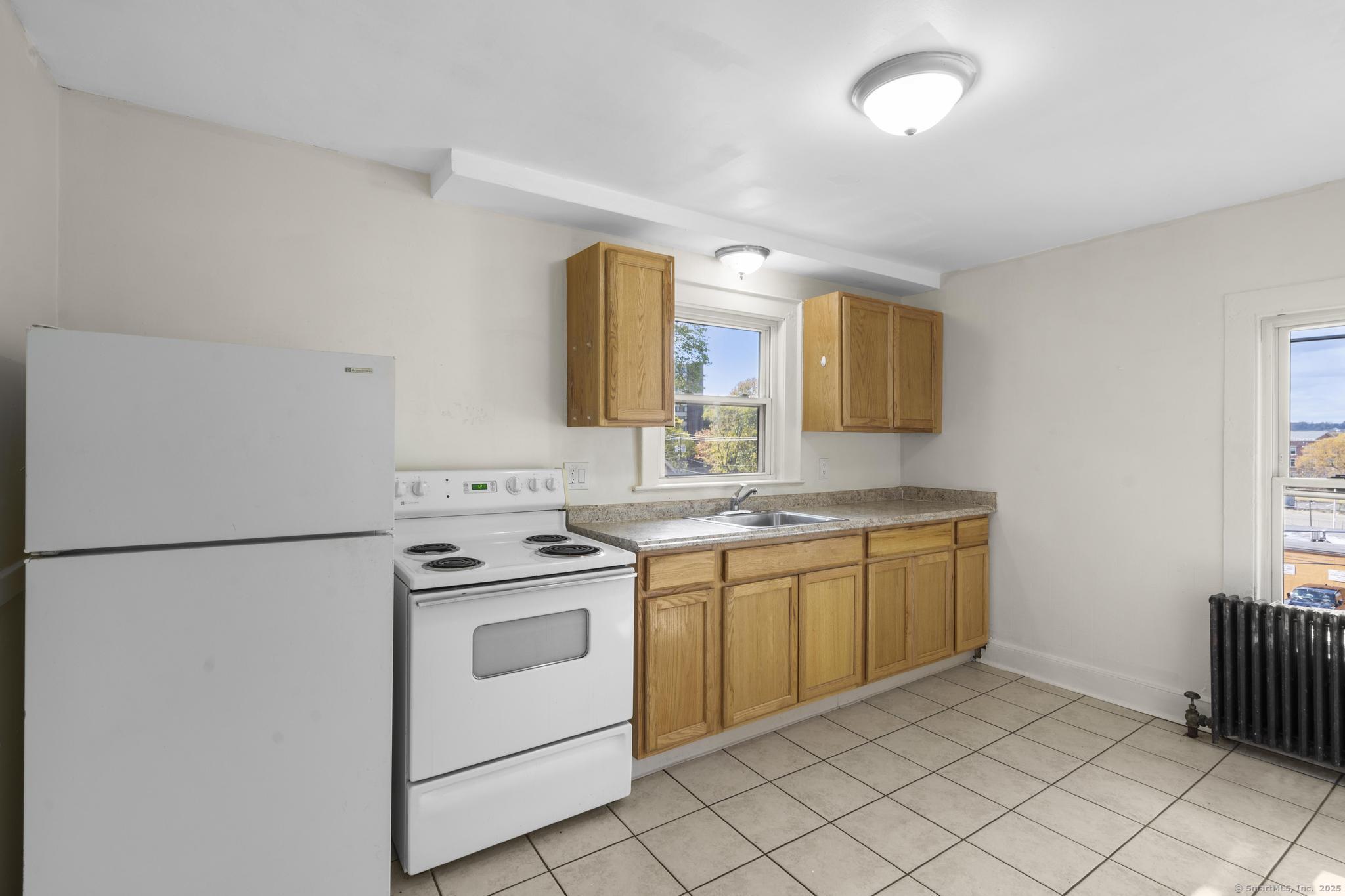 a kitchen with a stove sink and white cabinets