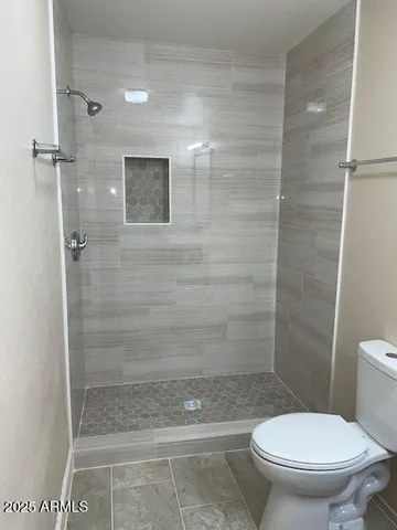 a bathroom with a toilet and a shower
