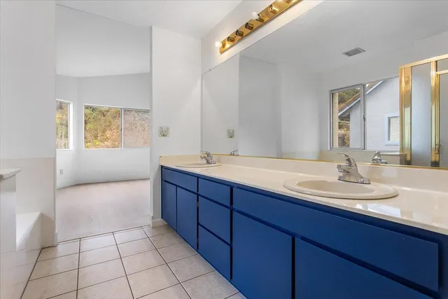 a spacious bathroom with a mirror and a shower