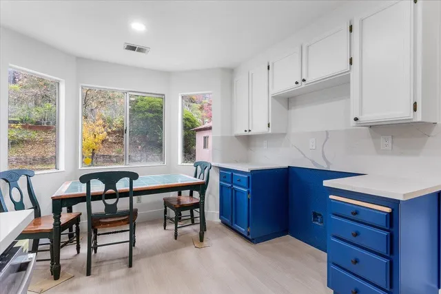 a kitchen with granite countertop wooden cabinets and dining table