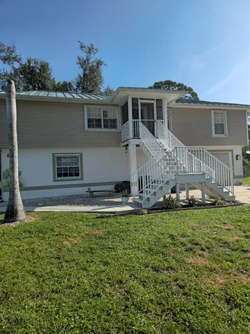 a view of a house with a yard and a table and chairs