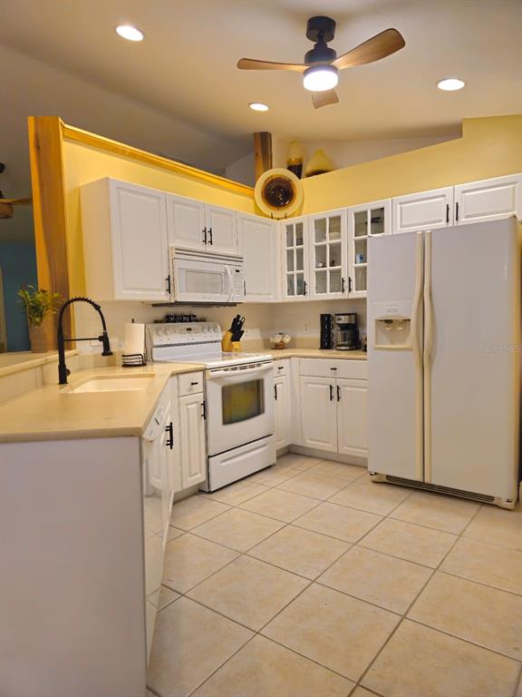 4472 Mariner Road Bonita Springs, FL 34134 - Photo 23 of 36 a kitchen with a sink a stove a refrigerator and cabinets