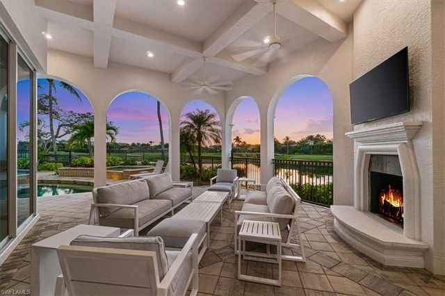 a living room with fireplace furniture and a large window
