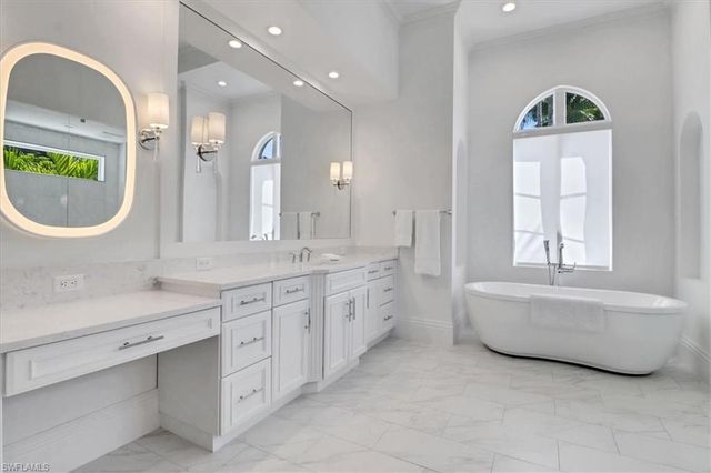 a bathroom with a double vanity sink mirror and bathtub