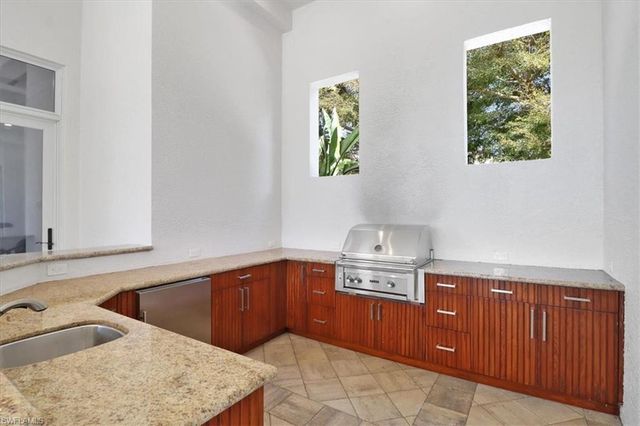 a kitchen with stainless steel appliances granite countertop a sink a stove and a wooden cabinets