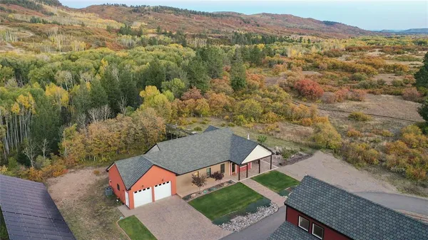 an aerial view of residential houses with outdoor space and trees