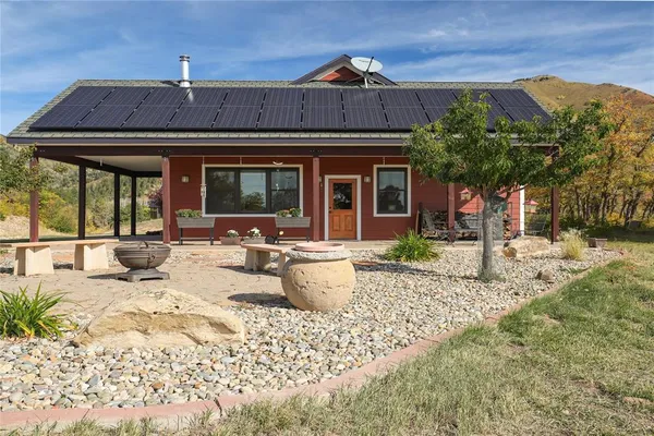 a view of a house with backyard and sitting area