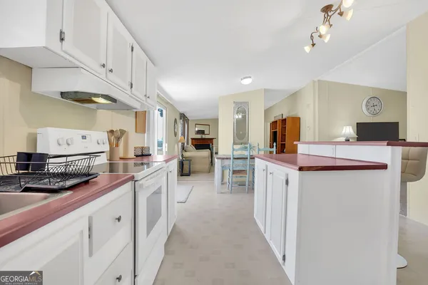 a kitchen with a table chairs refrigerator and cabinets