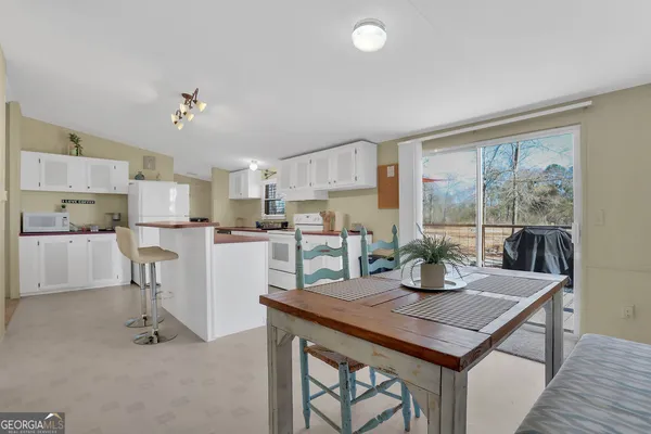a dining room with furniture and a floor to ceiling window
