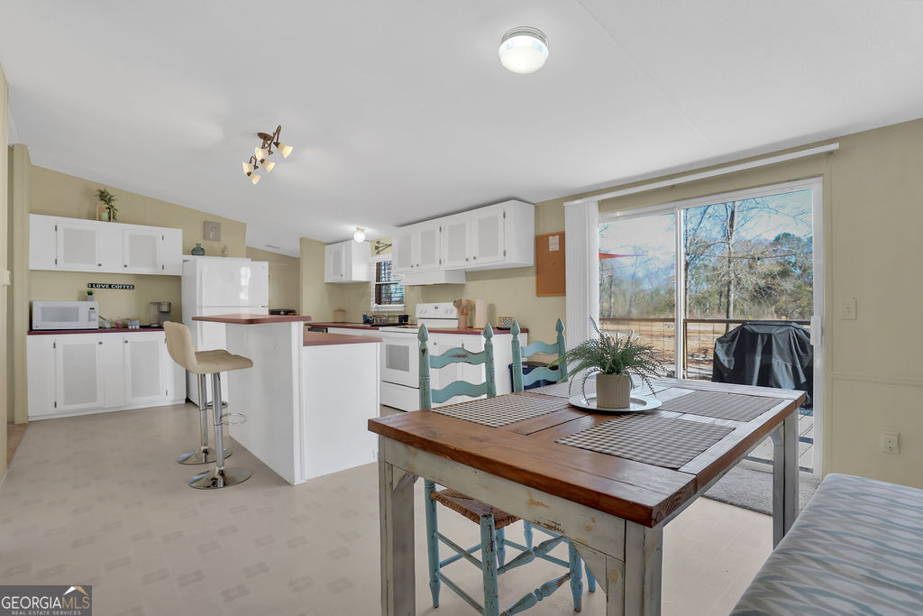 1775 Stoopto Road Sylvania, GA 30467 - Photo 13 of 66 a kitchen with a table chairs refrigerator and cabinets