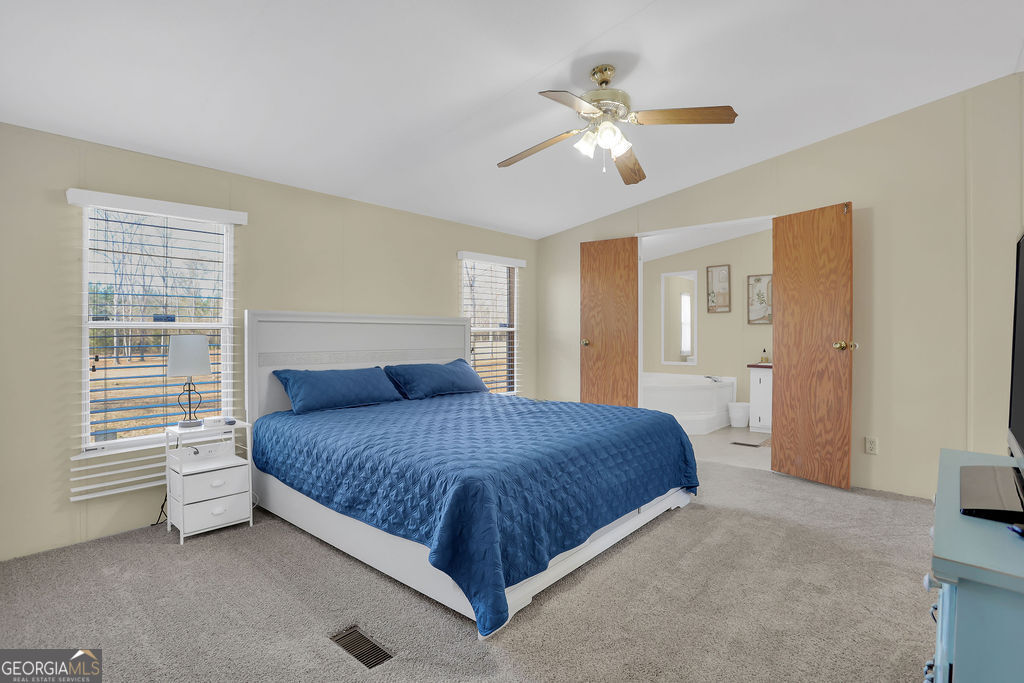 1775 Stoopto Road Sylvania, GA 30467 - Photo 22 of 66 a bedroom with a large bed and a chandelier