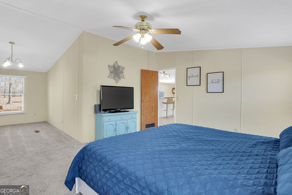 1775 Stoopto Road Sylvania, GA 30467 - Photo 25 of 66 a bedroom with a large bed and a flat screen tv