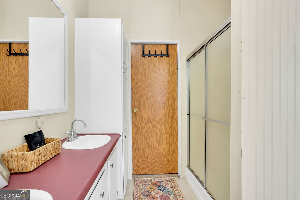 1775 Stoopto Road Sylvania, GA 30467 - Photo 29 of 66 a bathroom with a granite countertop sink and a mirror