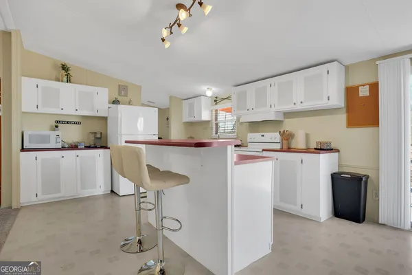 a kitchen with kitchen island a counter top space a sink stainless steel appliances and cabinets