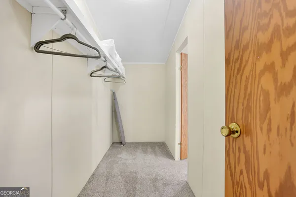 a bed sitting in a bedroom next to a window and a chandelier