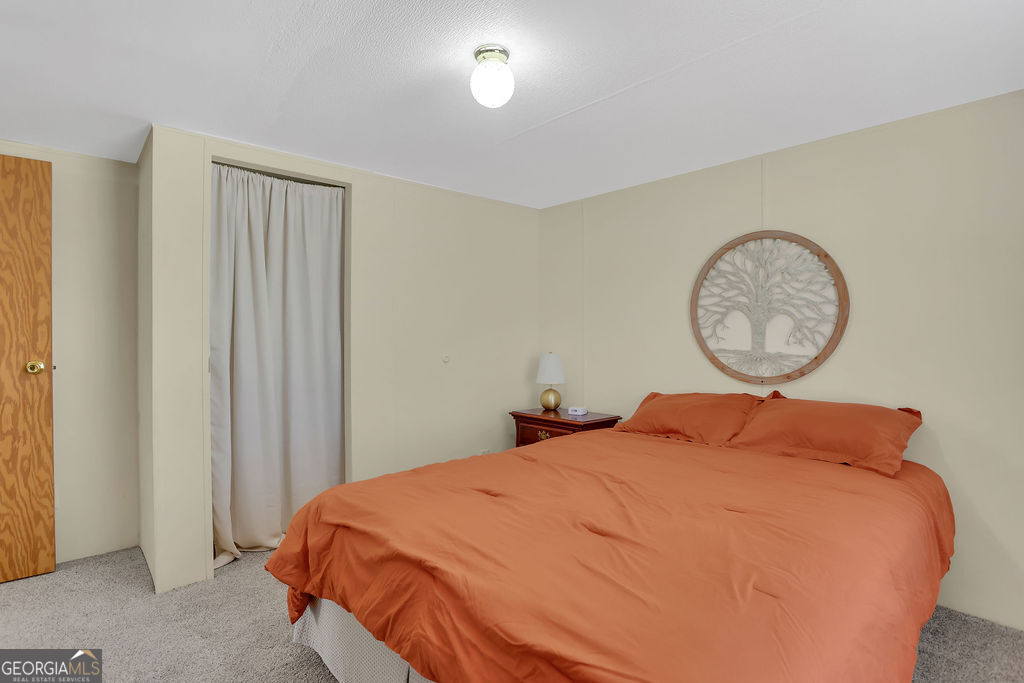 1775 Stoopto Road Sylvania, GA 30467 - Photo 37 of 66 a bed sitting in a bedroom next to a window and a chandelier