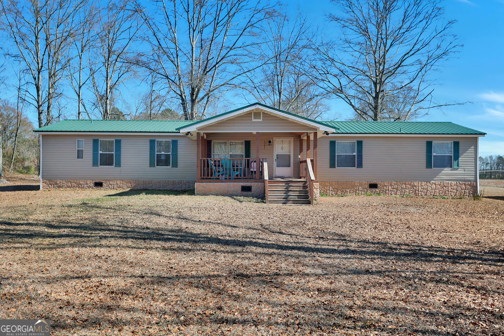 1775 Stoopto Road Sylvania, GA 30467 - Photo 49 of 66 a front view of a house with a yard covered with trees