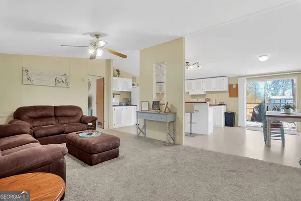 a living room with furniture and a dining table with kitchen view