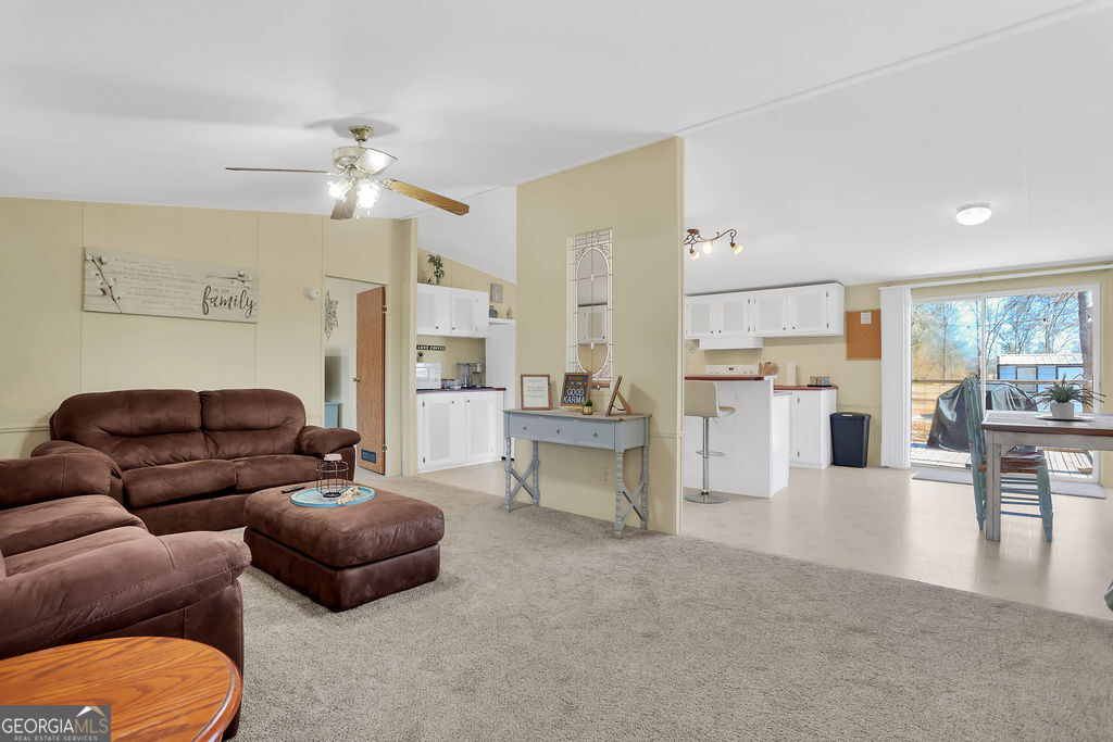 1775 Stoopto Road Sylvania, GA 30467 - Photo 6 of 66 a living room with furniture and a dining table with kitchen view