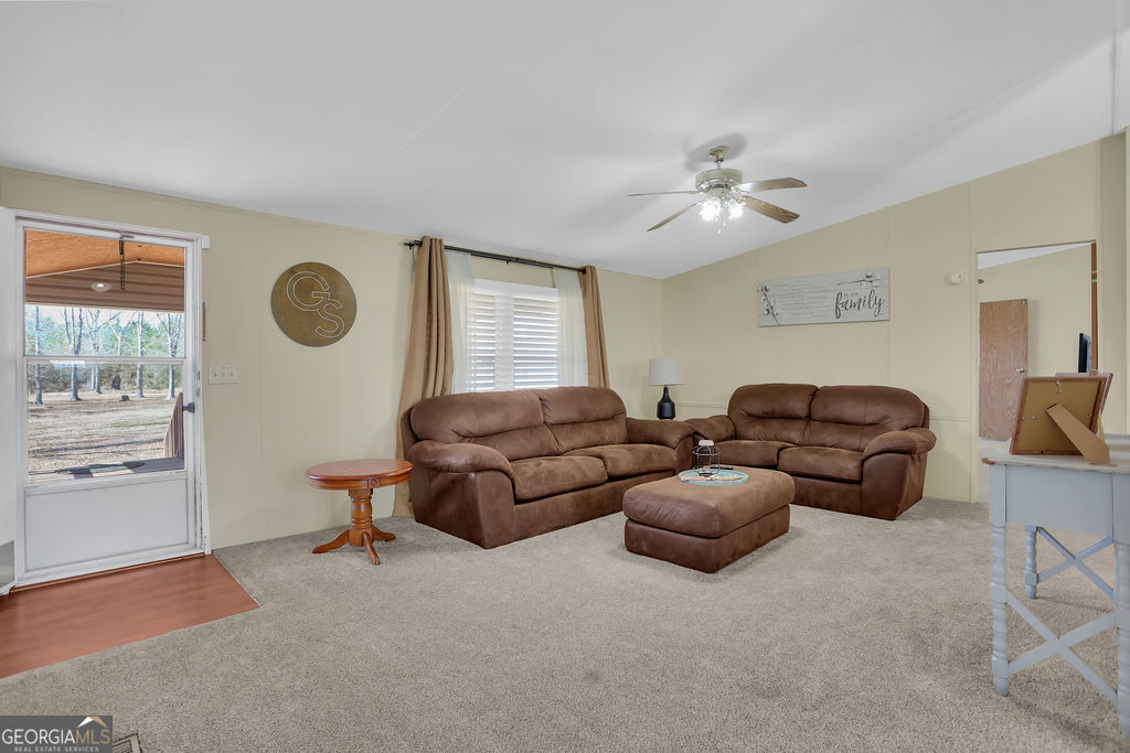 1775 Stoopto Road Sylvania, GA 30467 - Photo 8 of 66 a living room with furniture a window and a chandelier