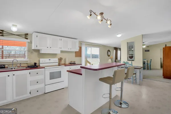 a kitchen with granite countertop white cabinets and chairs