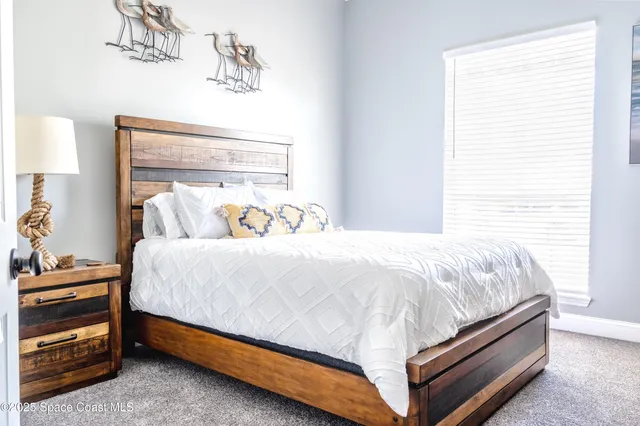 a bed sitting in a bedroom next to a window