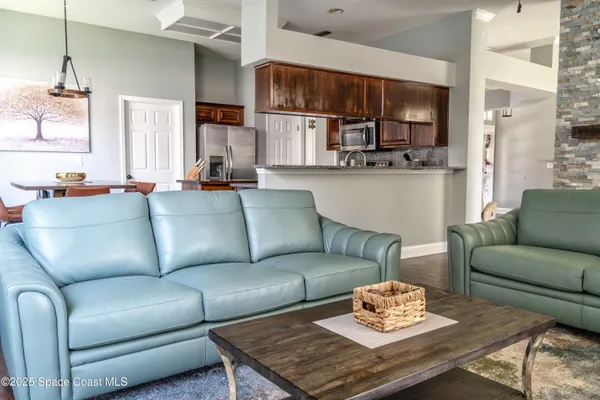a living room with furniture kitchen view and a window