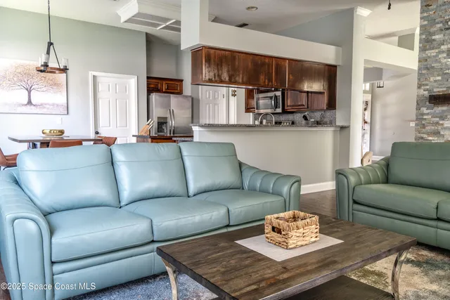 a living room with furniture kitchen view and a window