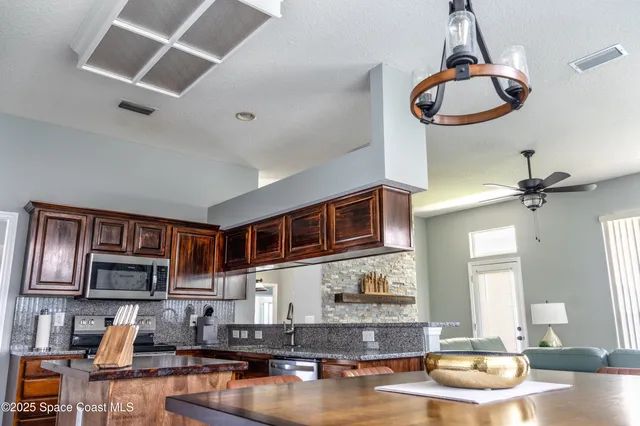 a kitchen with stainless steel appliances granite countertop a stove and cabinets