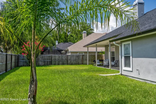 a view of a backyard with a garden and large trees