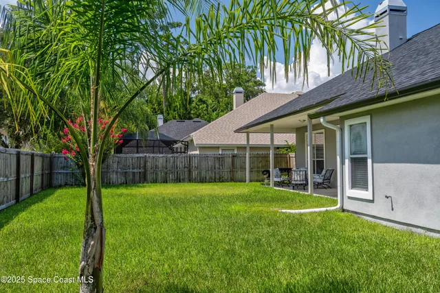 a view of a backyard with a garden and large trees