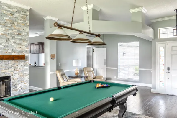 a room with pool table and windows